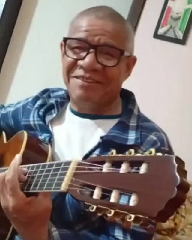 Josué tocando violão em casa