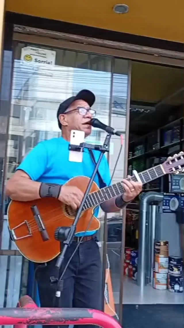 Josué Fontoura cantando na rua, com o violão